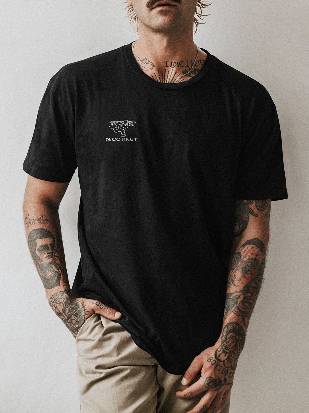 Foto von einem Mann mit schwarzem Shirt, auf dem das Logo in weiß steht.