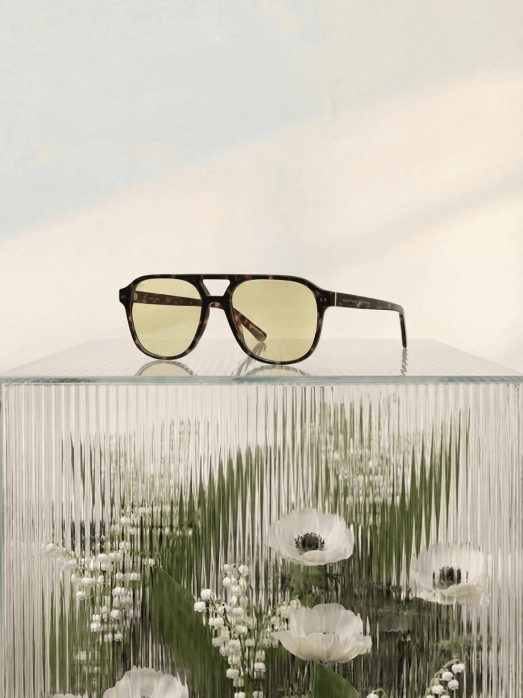 Sonnenbrille auf einem Glaswürfel.